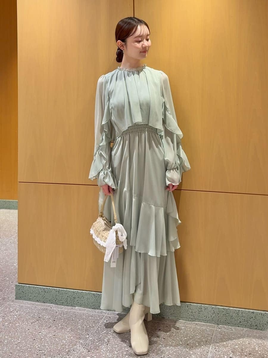 グリーン系のワンピース、ホワイト系のカーディガン/ボレロを着用したレディースの冬コーディネートの4枚目の写真