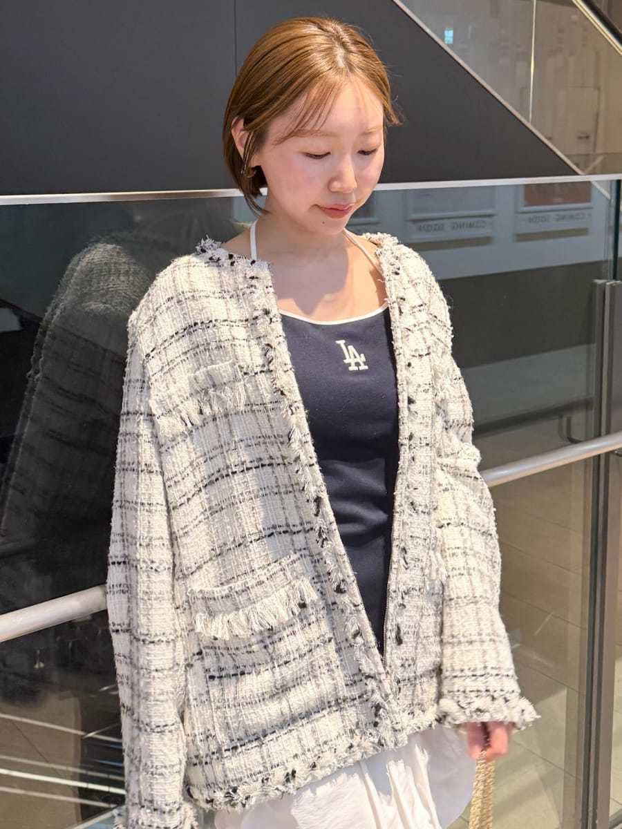 ホワイト系のノーカラージャケット、ブルー系のワンピース、ブラック系のショルダーバッグを着用したレディースの春コーディネートの4枚目の写真