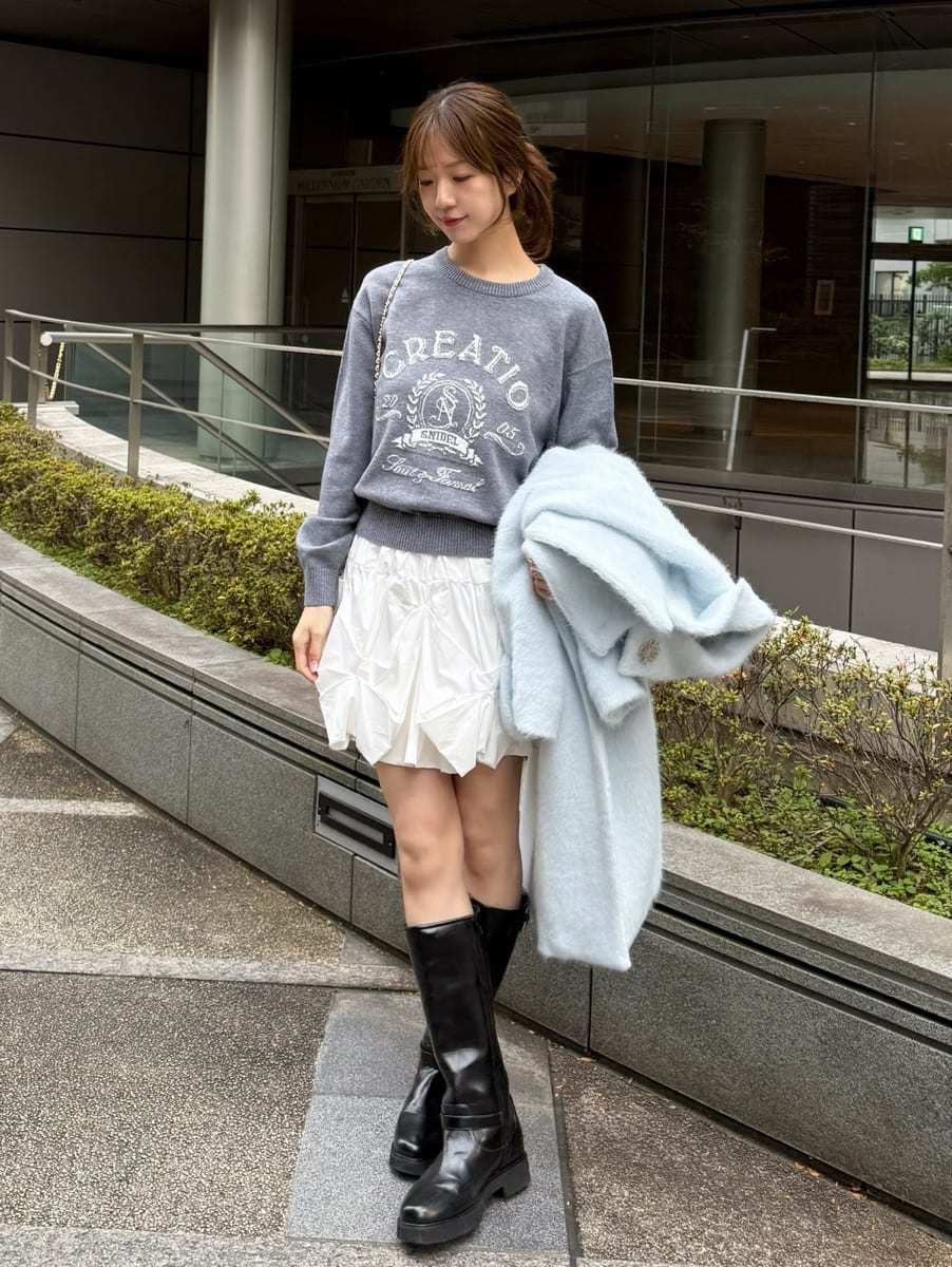 ブラック系のブーツ、ホワイト系のショルダーバッグ、ブルー系のチェスターコートを着用したレディースの冬コーディネートの4枚目の写真