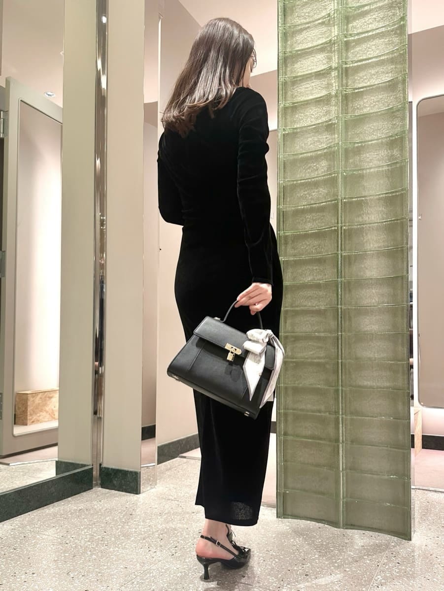 ブラック系のワンピース、ブラック系のハンドバッグを着用したレディースの秋コーディネートの5枚目の写真