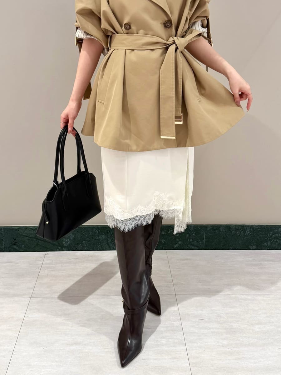 ベージュ系のトレンチコート、ホワイト系のスカート、ホワイト系のその他トップスを着用したレディースの秋コーディネートの6枚目の写真