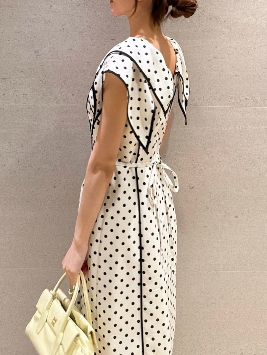 イエロー系のボストンバッグ、ホワイト系のワンピースを着用したレディースの春コーディネートの4枚目の写真