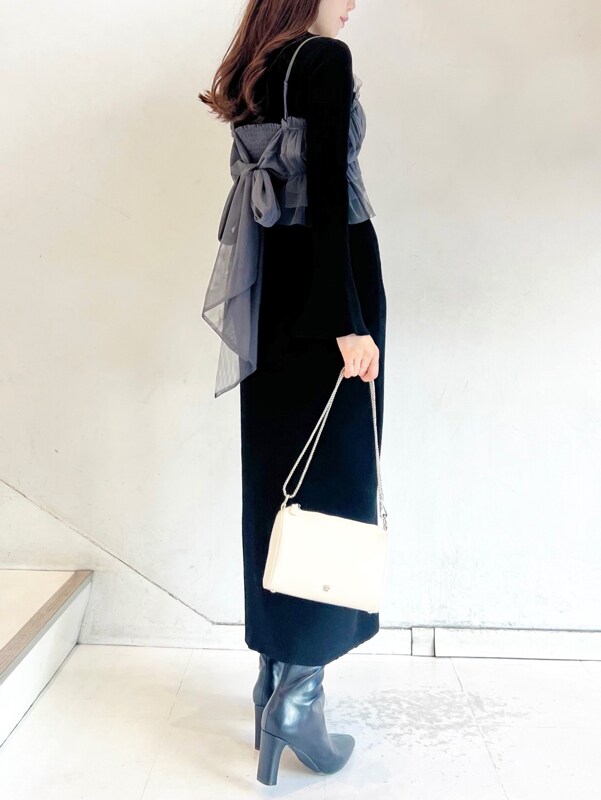 ブラック系のワンピース、ブラック系のブーツ、ベージュ系のショルダーバッグを着用したレディースの秋コーディネートの5枚目の写真