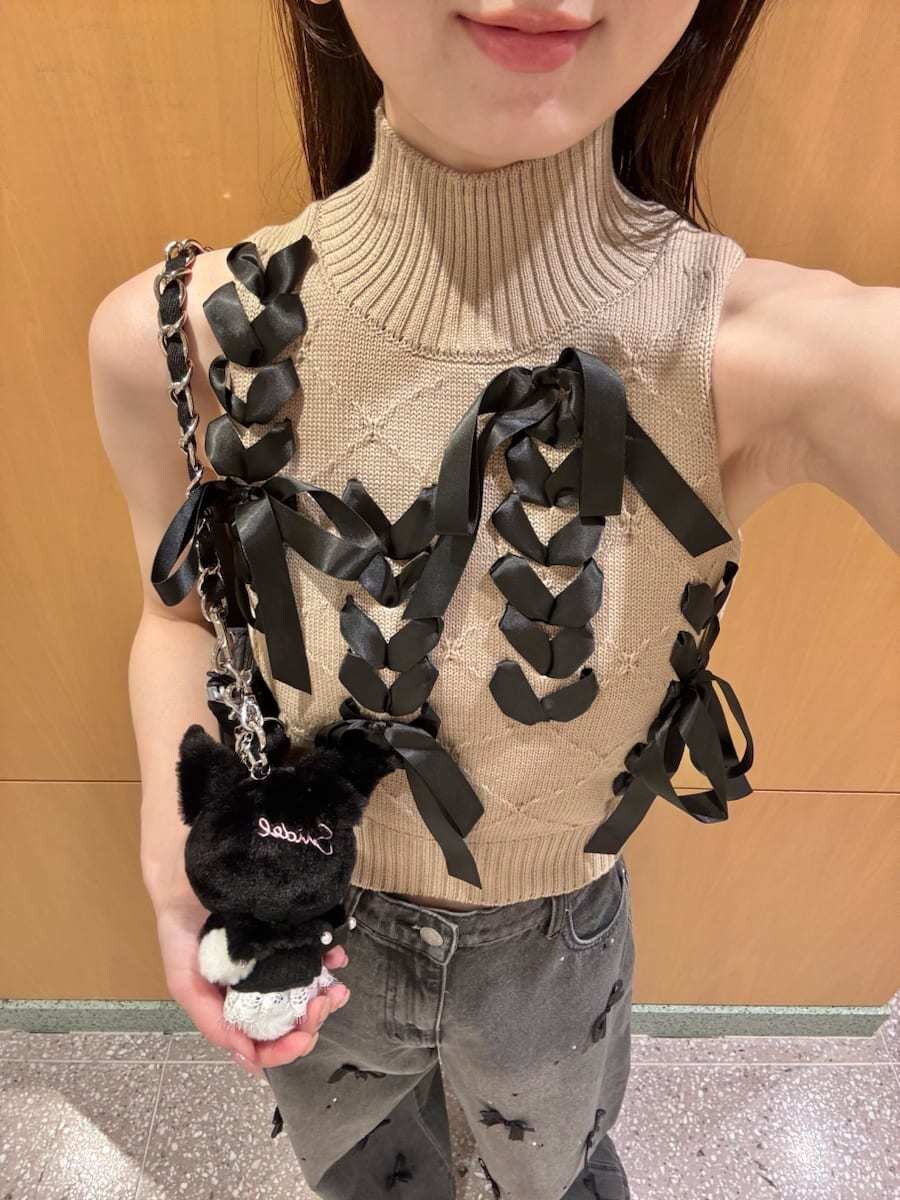 ブラック系のショルダーバッグ、ブラック系のその他パンツ、ベージュ系のニット/セーターを着用したレディースの夏コーディネートの8枚目の写真