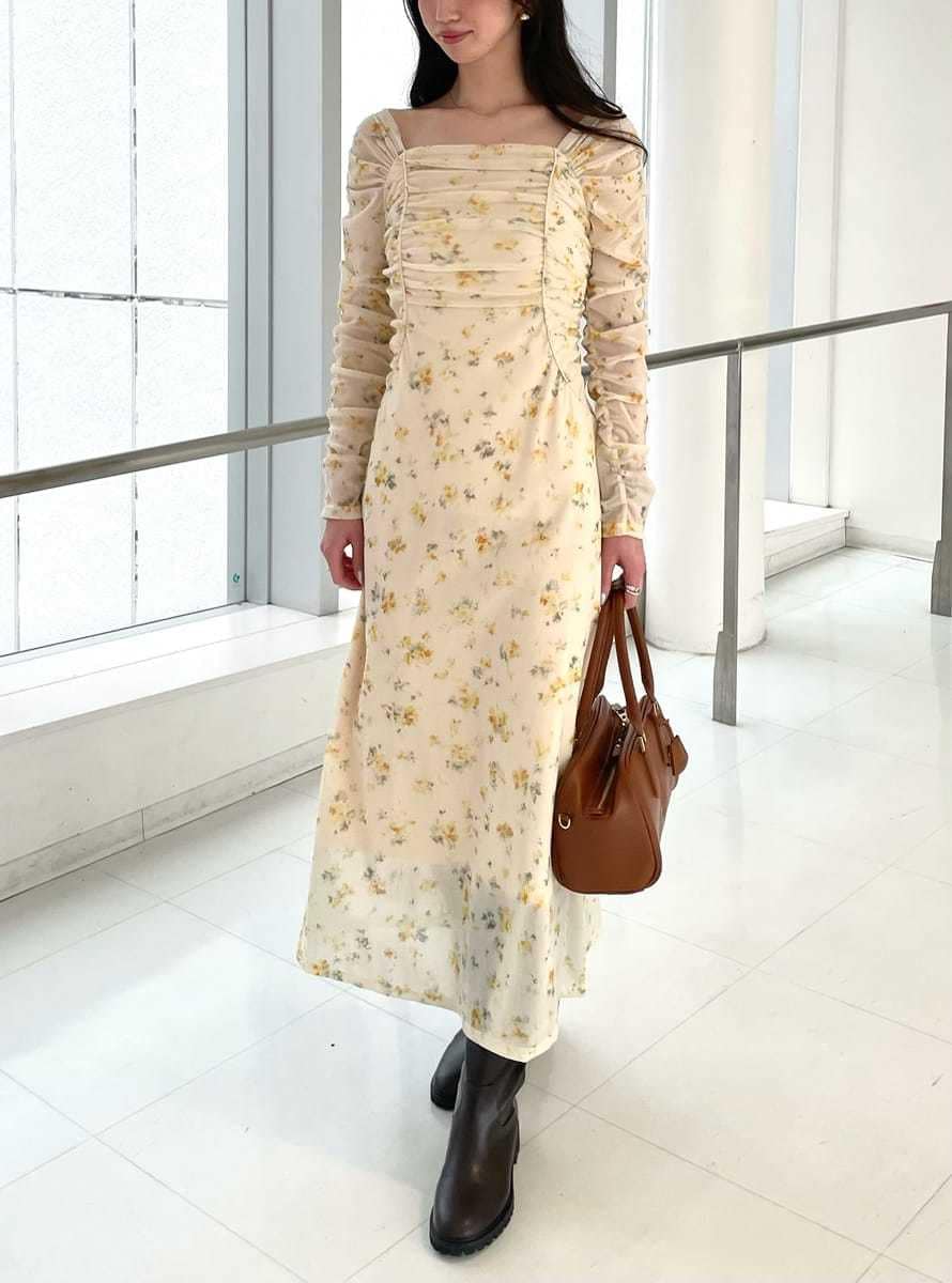 イエロー系のワンピース、ベージュ系のトレンチコート、イエロー系のボストンバッグを着用したレディースの冬コーディネートの4枚目の写真