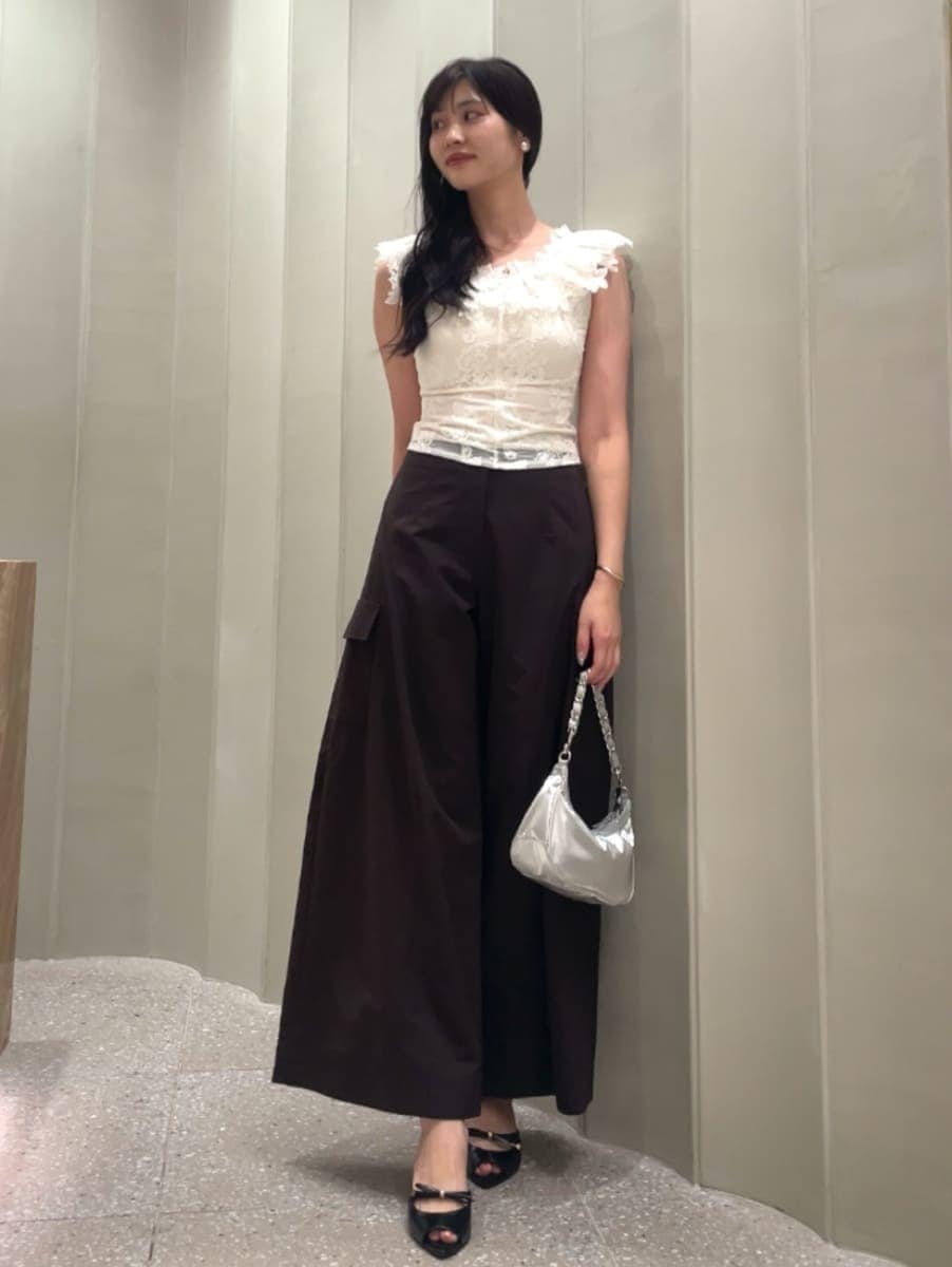 シルバー系のショルダーバッグ、ブラウン系のその他パンツ、ホワイト系のTシャツ/カットソーを着用したレディースの夏コーディネートの3枚目の写真