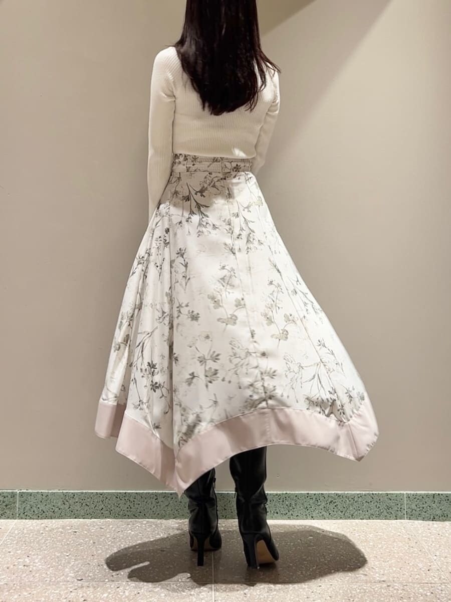 ホワイト系のニット/セーター、ベージュ系のスカート、ブラック系のハンドバッグを着用したレディースの秋コーディネートの2枚目の写真