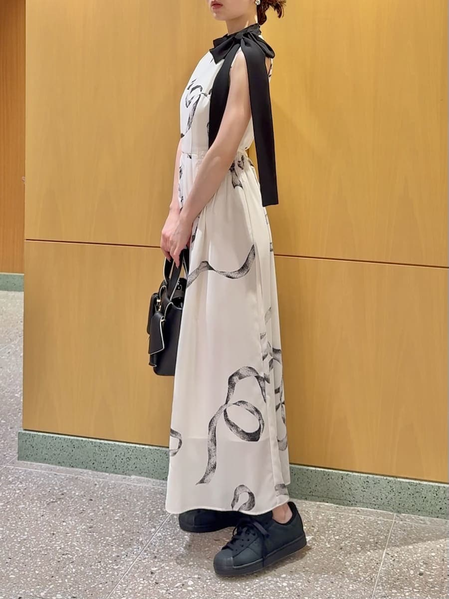 ホワイト系のワンピース、ブラック系のブルゾン、ブラック系のハンドバッグを着用したレディースの春コーディネートの4枚目の写真