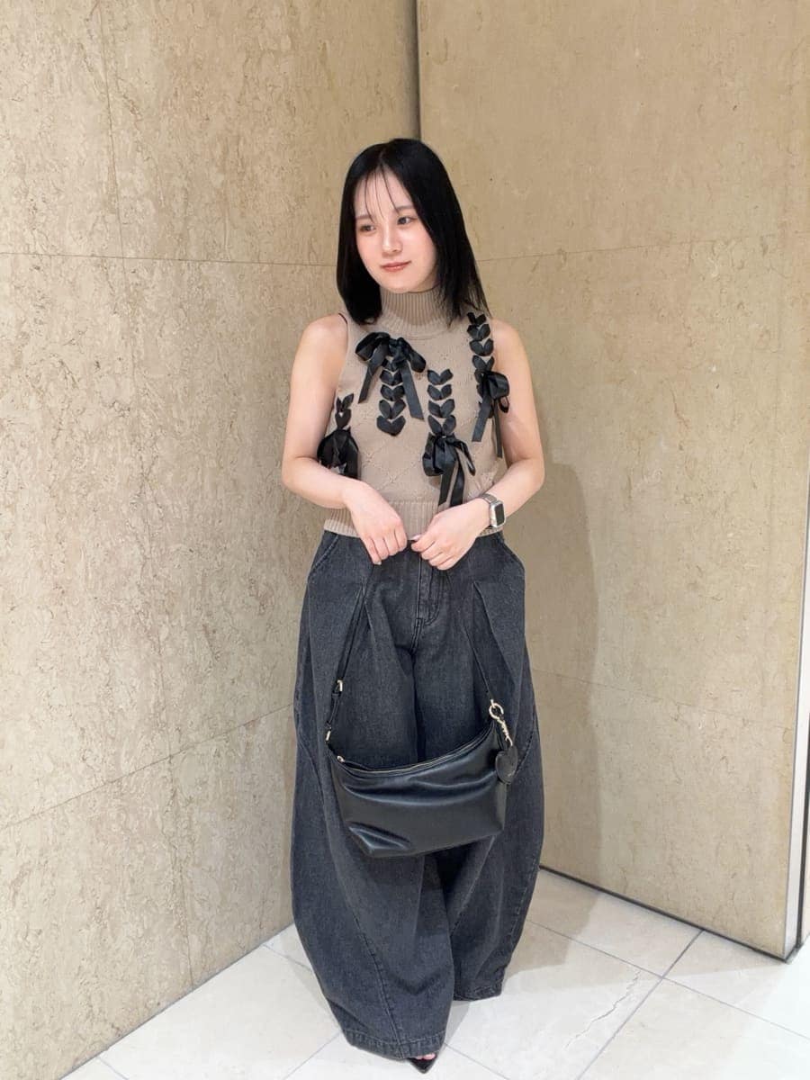 ブラック系のデニムパンツ、ベージュ系のニット/セーター、ブラック系のサンダルを着用したレディースの夏コーディネートの2枚目の写真