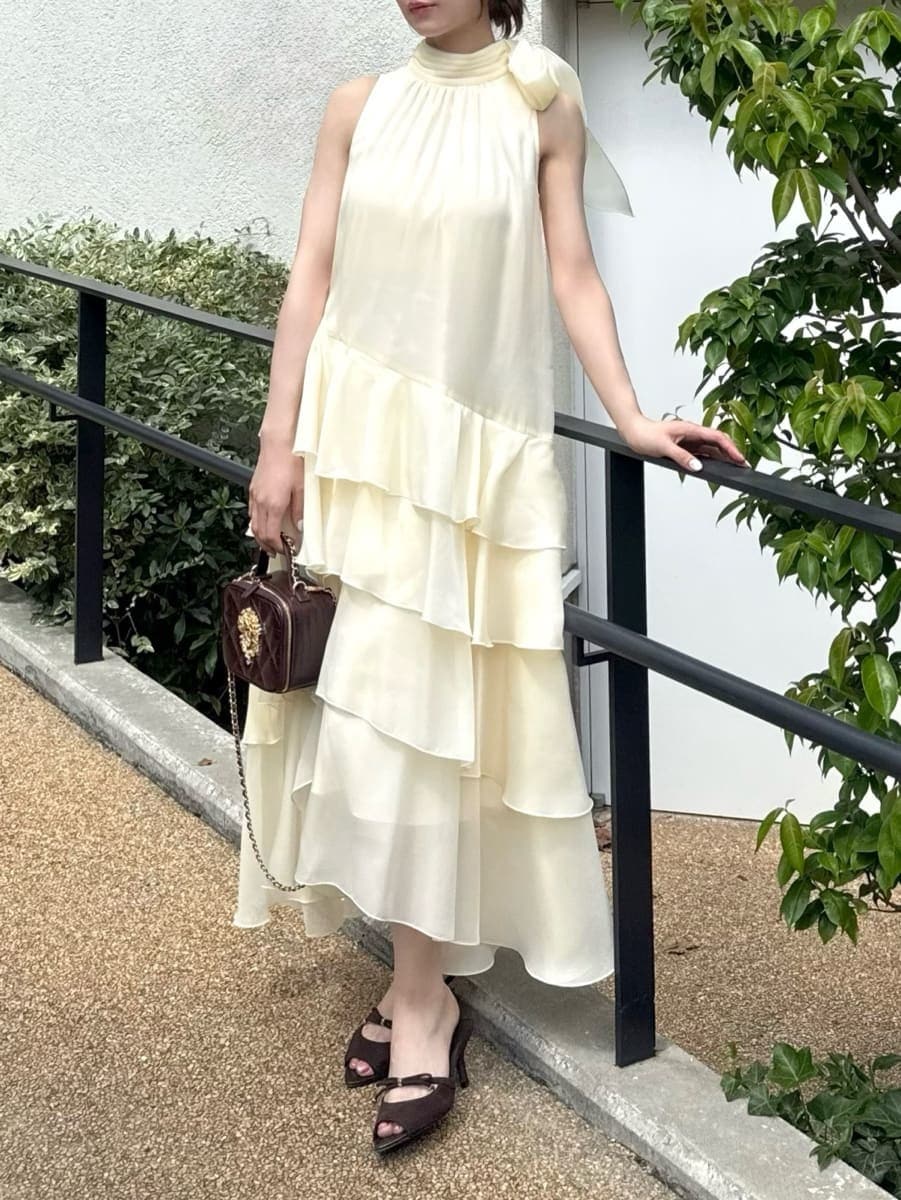 イエロー系のドレス、ブラウン系のサンダル、レッド系のショルダーバッグを着用したレディースの夏コーディネートの3枚目の写真