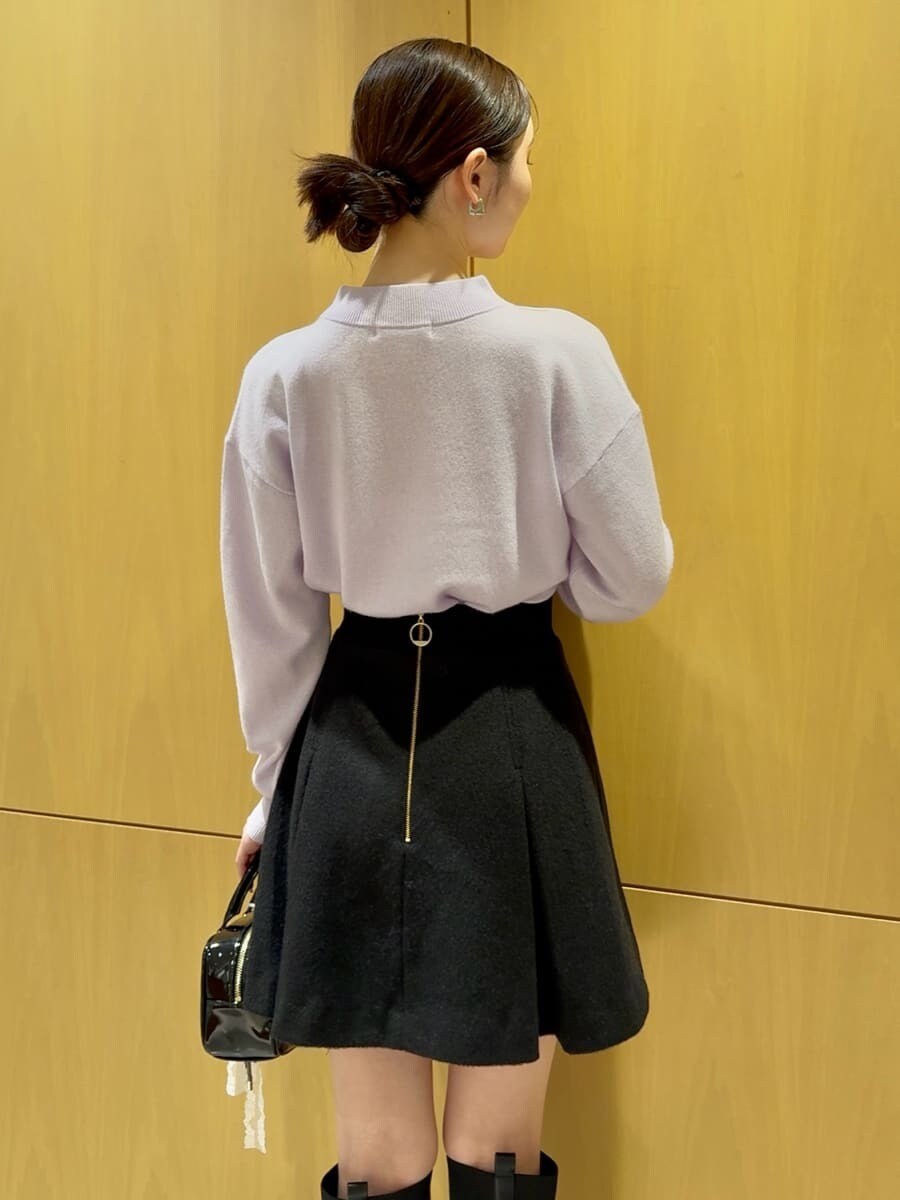 パープル系のニット/セーター、ブラック系のスカート、ブラック系のボストンバッグを着用したレディースの秋コーディネートの3枚目の写真