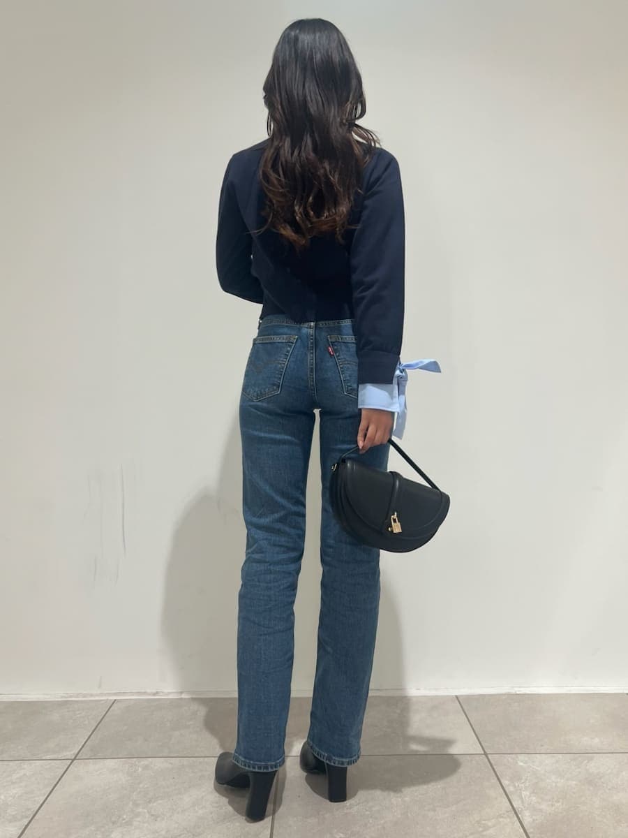 ブルー系のニット/セーター、ブルー系のデニムパンツ、ブラック系のブーツを着用したレディースの秋コーディネートの3枚目の写真