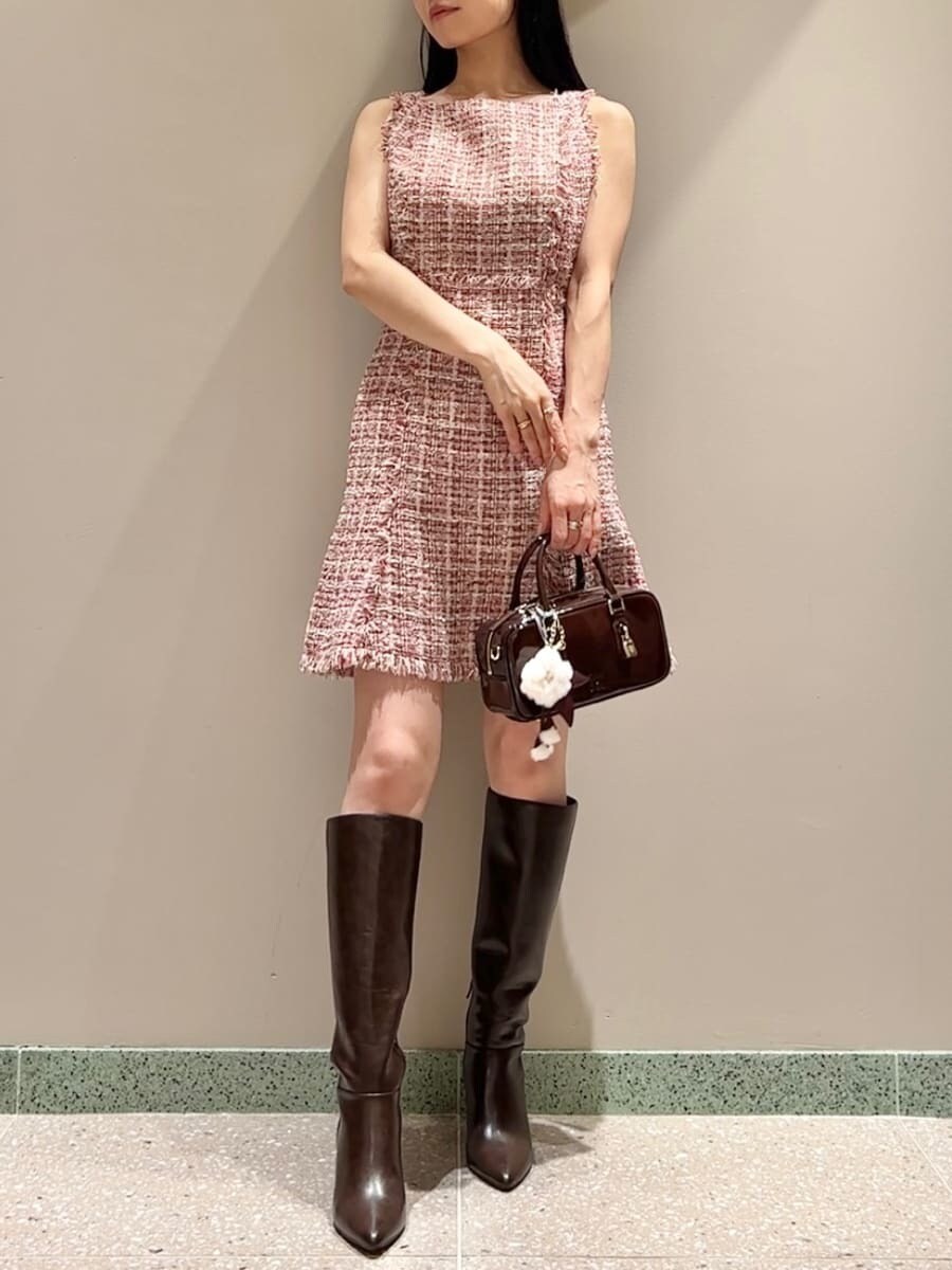 ピンク系のワンピース、ブラウン系のブーツ、ブラウン系のボストンバッグを着用したレディースの秋コーディネートの2枚目の写真