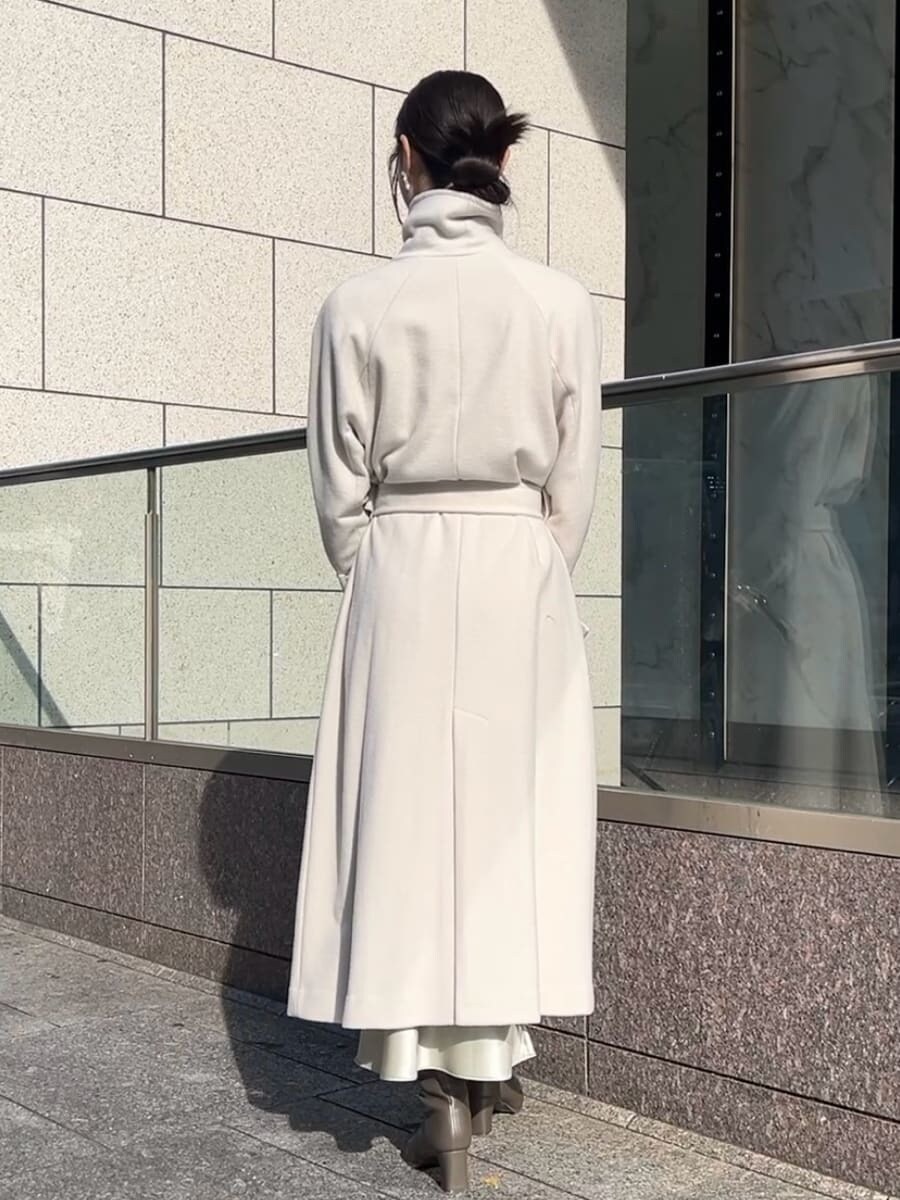 ホワイト系のチェスターコート、ホワイト系のワンピース、ホワイト系のボストンバッグを着用したレディースの秋コーディネートの6枚目の写真