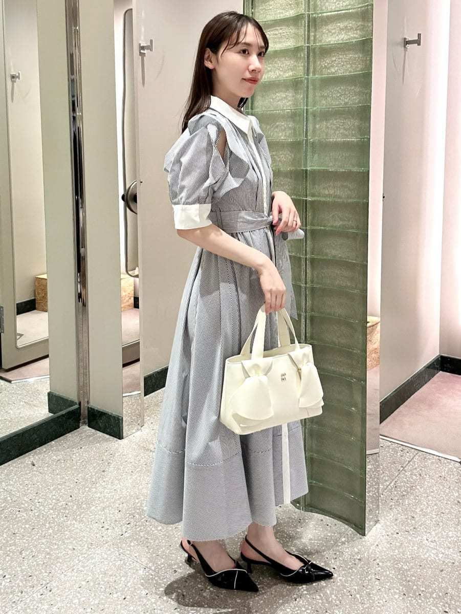 その他のワンピース、ブラック系のパンプス、ホワイト系のハンドバッグを着用したレディースの冬コーディネートの3枚目の写真