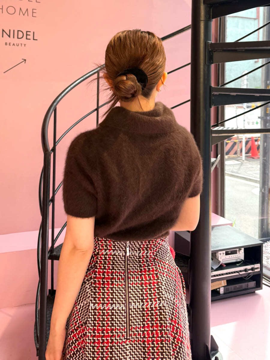 ブラウン系のニット/セーター、レッド系のスカート、ブラウン系のブーツを着用したレディースの秋コーディネートの7枚目の写真