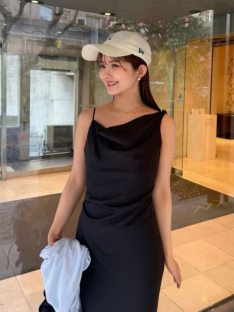 ブラック系のワンピース、ブルー系のカーディガン/ボレロ、ホワイト系のキャップを着用したレディースの春コーディネートの4枚目の写真