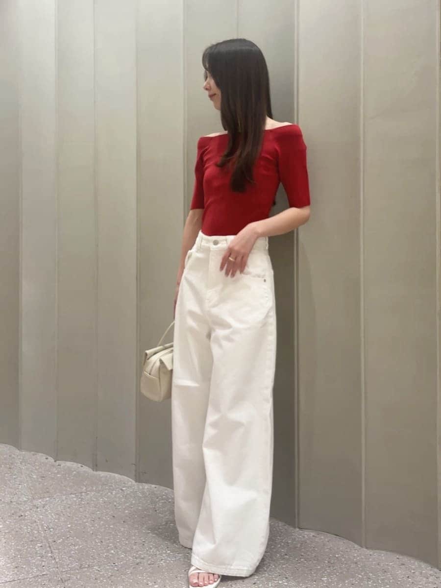 ホワイト系のボストンバッグ、ホワイト系のデニムパンツ、レッド系のニット/セーターを着用したレディースの夏コーディネートの2枚目の写真
