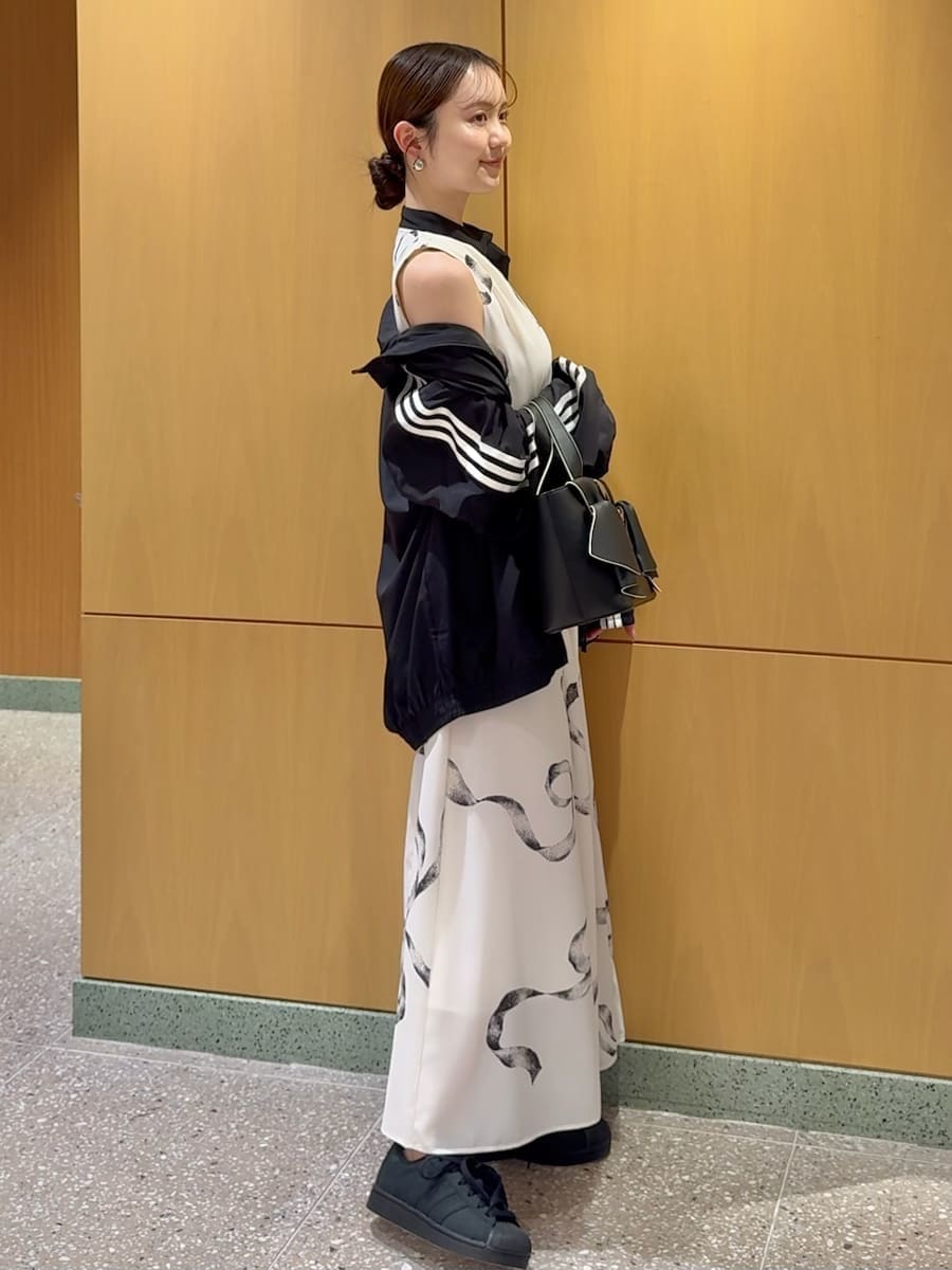 ホワイト系のワンピース、ブラック系のブルゾン、ブラック系のハンドバッグを着用したレディースの春コーディネートの2枚目の写真