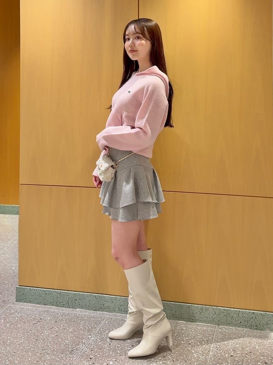 ホワイト系のショルダーバッグ、ピンク系のニット/セーター、ホワイト系のブーツを着用したレディースの冬コーディネートの5枚目の写真