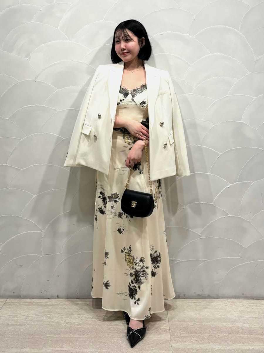 ホワイト系のテーラードジャケット、イエロー系のワンピース、ブラック系のパンプスを着用したレディースの春コーディネートの6枚目の写真