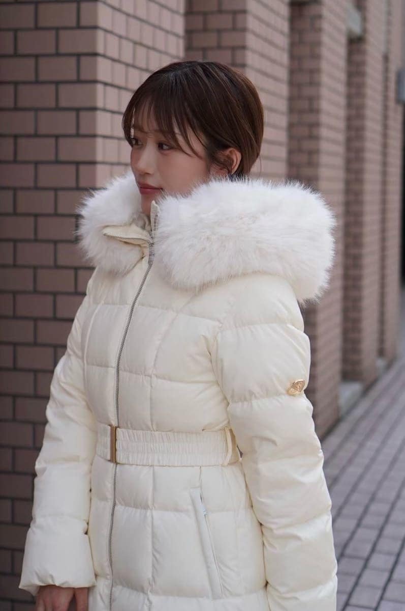 ブラック系のブーツ、ブラック系のボストンバッグ、ホワイト系のダウンジャケット/コートを着用したレディースの秋コーディネートの3枚目の写真