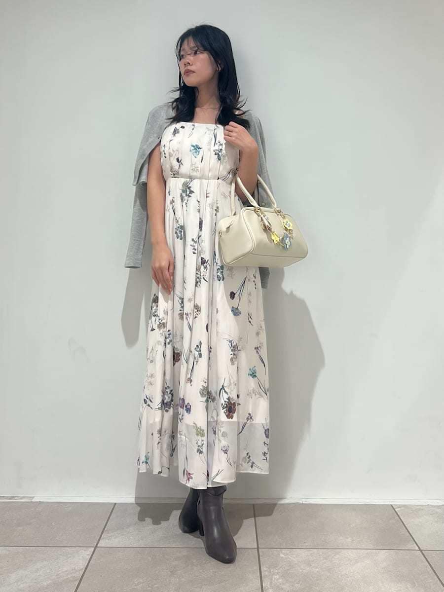 グレー系のブーツ、ホワイト系のワンピース、ホワイト系のボストンバッグを着用したレディースの冬コーディネートの4枚目の写真