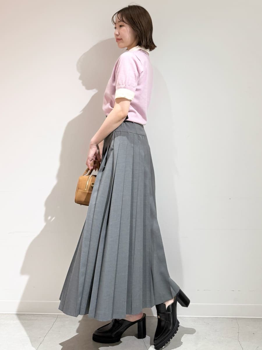 イエロー系のボストンバッグ、ピンク系のニット/セーター、グレー系のスカートを着用したレディースの夏コーディネートの9枚目の写真