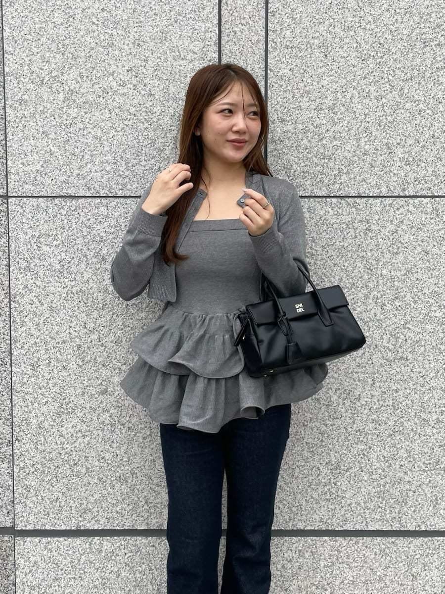 シルバー系のニット/セーター、シルバー系のカーディガン/ボレロ、ブルー系のデニムパンツを着用したレディースの春コーディネートの3枚目の写真