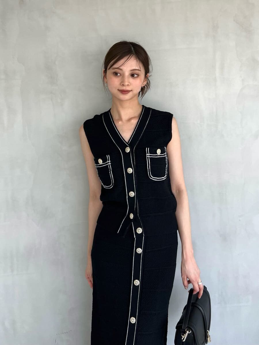 ブルー系のニット/セーター、ブルー系のスカート、ブラック系のハンドバッグを着用したレディースの夏コーディネートの4枚目の写真