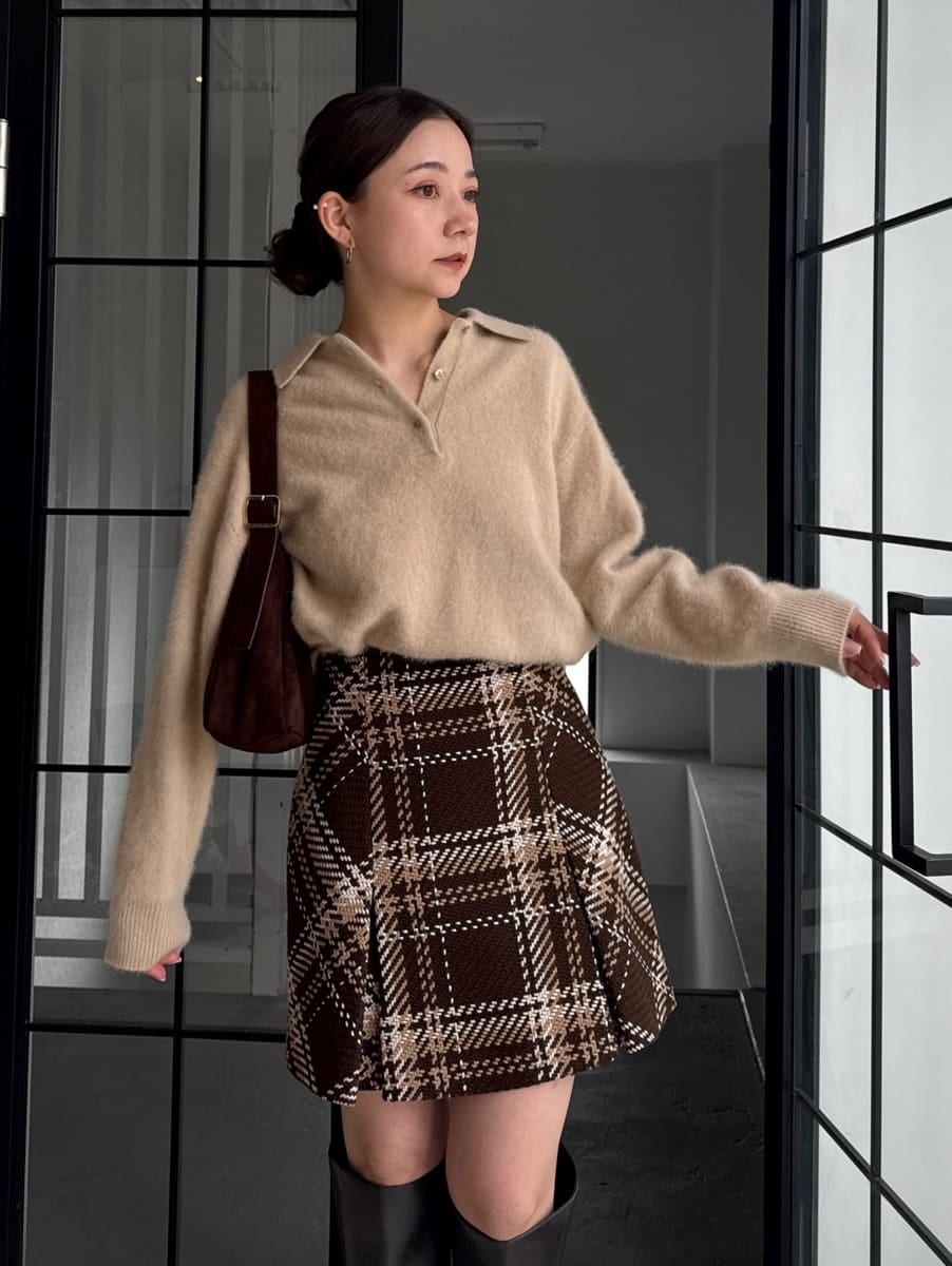 ベージュ系のニット/セーター、ブラウン系のスカートを着用したレディースの秋コーディネートの2枚目の写真
