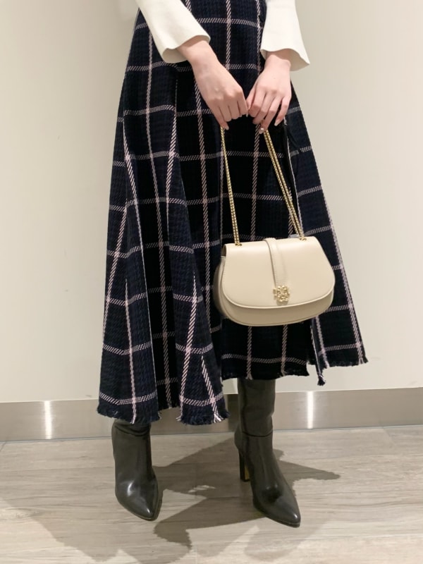 ブルー系のスカート、ホワイト系のニット/セーター、グレー系のブーツを着用したレディースの冬コーディネートの4枚目の写真