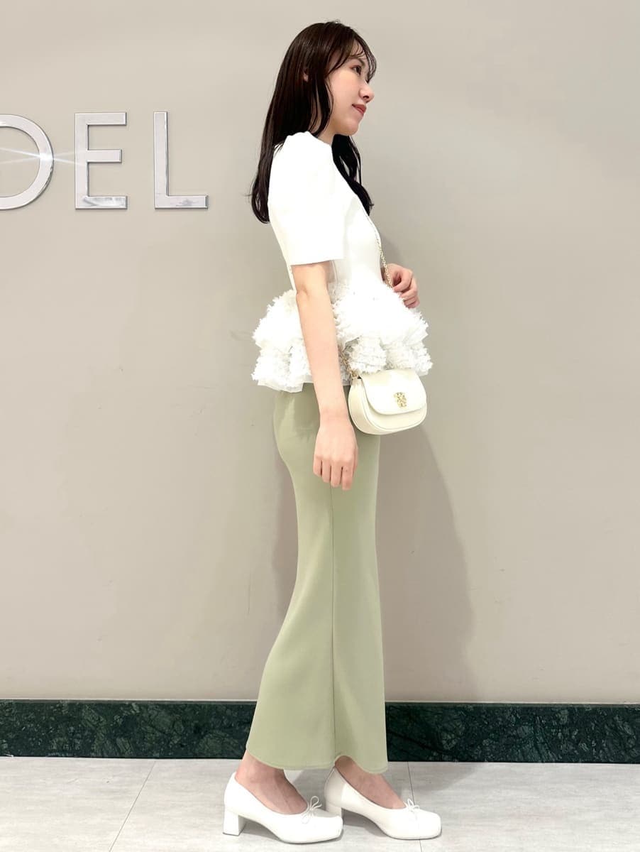 グリーン系のスカート、ホワイト系のニット/セーター、ホワイト系のショルダーバッグを着用したレディースの春コーディネートの4枚目の写真