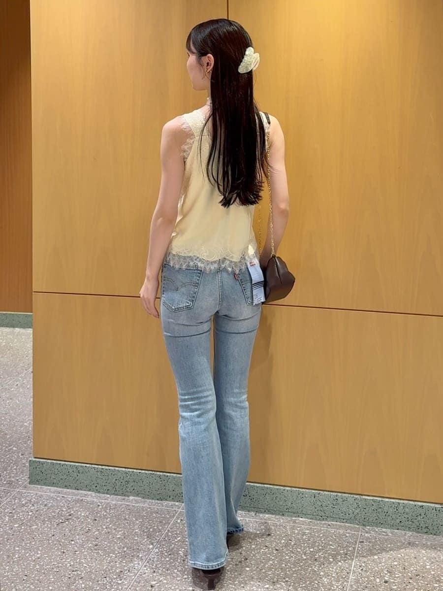 ブルー系のデニムパンツ、イエロー系のキャミソール、その他のイヤリングを着用したレディースの夏コーディネートの3枚目の写真