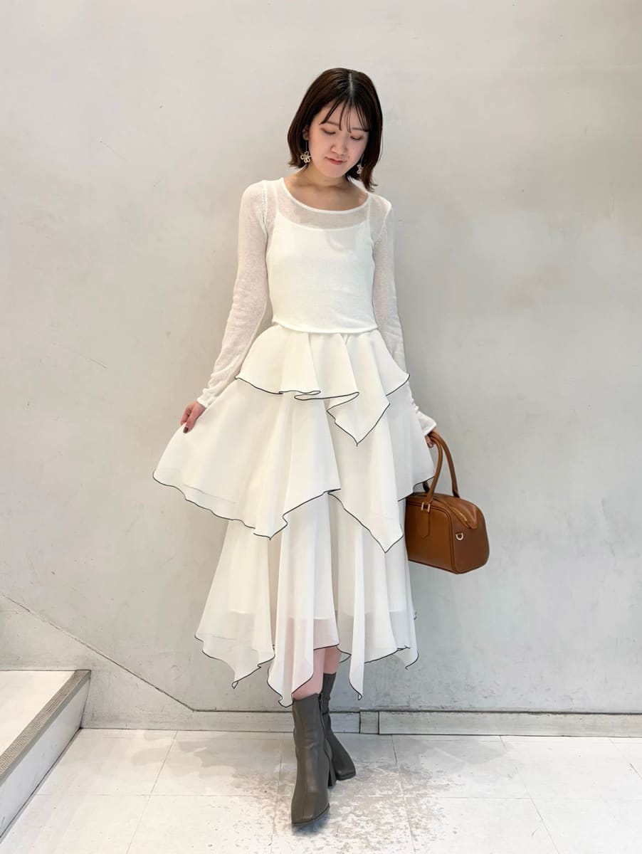 ホワイト系のワンピース、イエロー系のボストンバッグ、その他のイヤリングを着用したレディースの冬コーディネートの5枚目の写真