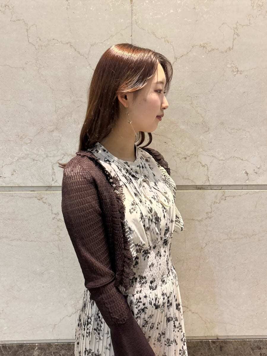 ベージュ系のワンピース、ホワイト系のカーディガン/ボレロ、ブラウン系のパンプスを着用したレディースの冬コーディネートの8枚目の写真