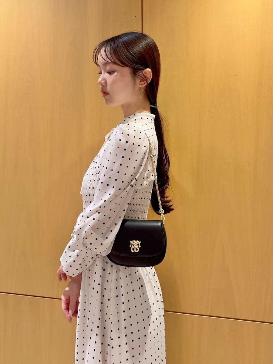 ブラック系のパンプス、ブラック系のショルダーバッグ、ホワイト系のワンピースを着用したレディースの春コーディネートの7枚目の写真