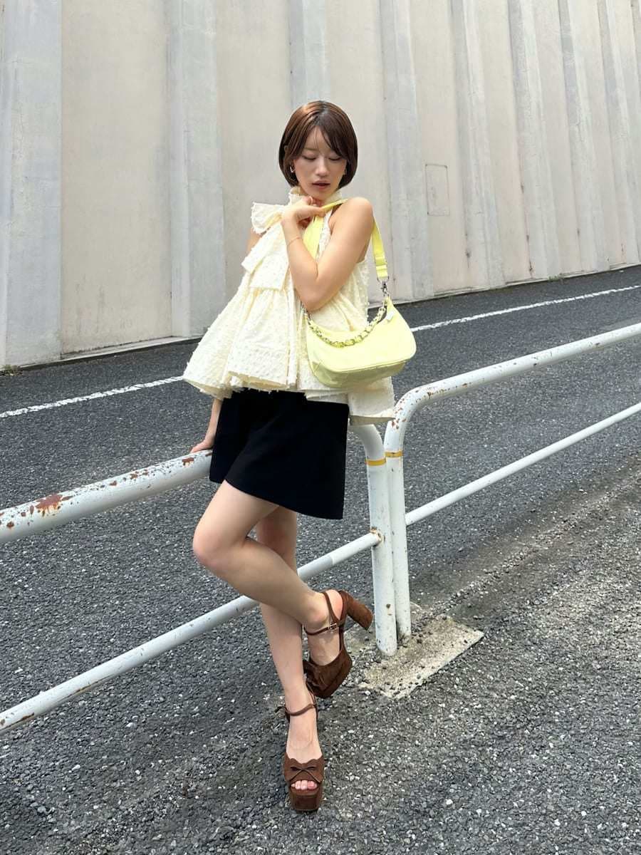 ブラック系のその他パンツ、ホワイト系のシャツ/ブラウス、イエロー系のショルダーバッグを着用したレディースの春コーディネートの2枚目の写真