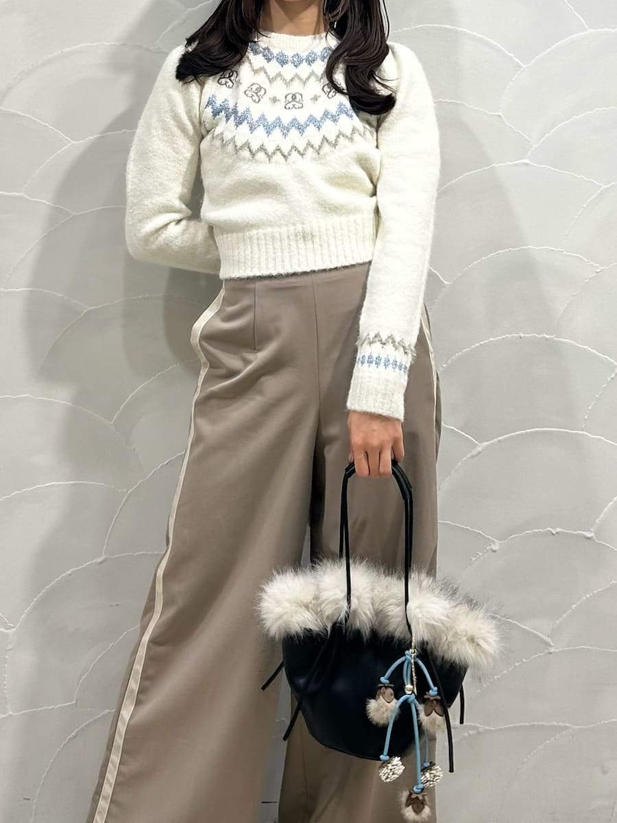 ブラウン系のその他パンツ、ホワイト系のニット/セーター、ブラック系のハンドバッグを着用したレディースの冬コーディネートの2枚目の写真