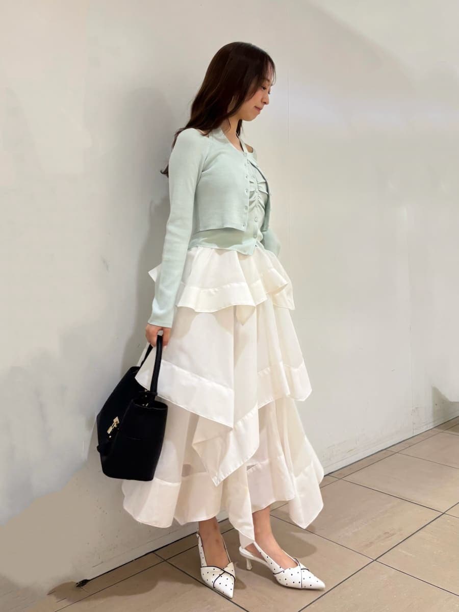 ホワイト系のスカート、グリーン系のカーディガン/ボレロ、その他のパンプスを着用したレディースの春コーディネートの3枚目の写真