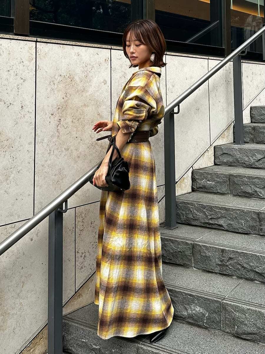 ブラック系のボストンバッグ、ホワイト系のピアス（両耳用）、ブラウン系のベルトを着用したレディースの冬コーディネートの5枚目の写真