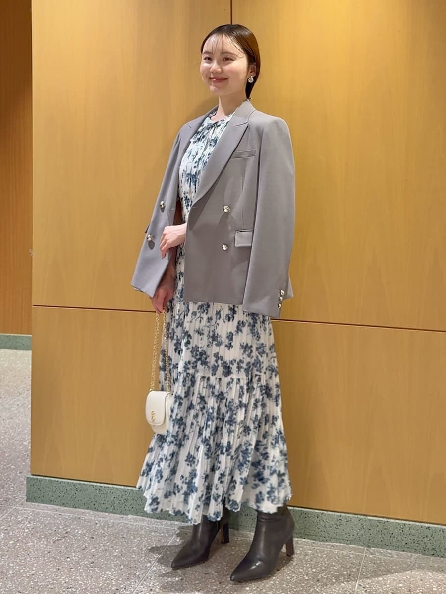 グレー系のブーツ、ブルー系のワンピース、グレー系のテーラードジャケットを着用したレディースの春コーディネートの2枚目の写真