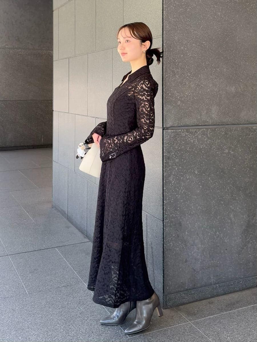 グレー系のブーツ、ブラック系のワンピース、ホワイト系のハンドバッグを着用したレディースの冬コーディネートの2枚目の写真