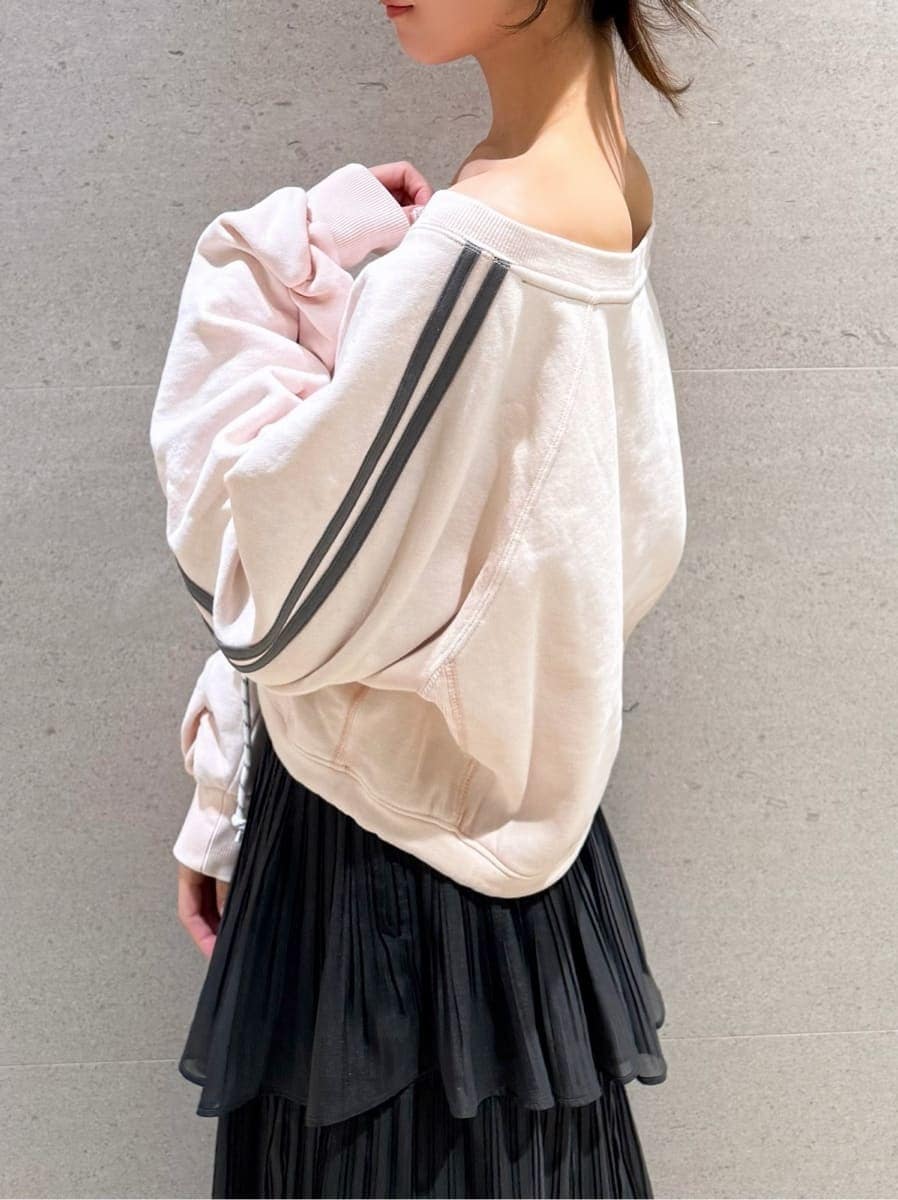 グレー系のスカート、ピンク系のスウェット、その他のイヤリングを着用したレディースの秋コーディネートの4枚目の写真