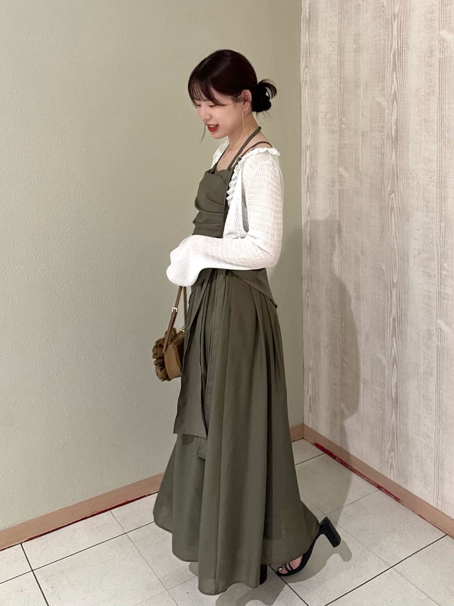 グリーン系のワンピース、ホワイト系のカーディガン/ボレロ、ブラウン系のハンドバッグを着用したレディースの春コーディネートの2枚目の写真