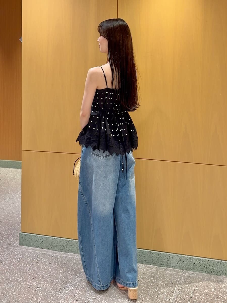 ブラック系のかごバッグ、ブルー系のデニムパンツ、その他のキャミソールを着用したレディースの夏コーディネートの3枚目の写真