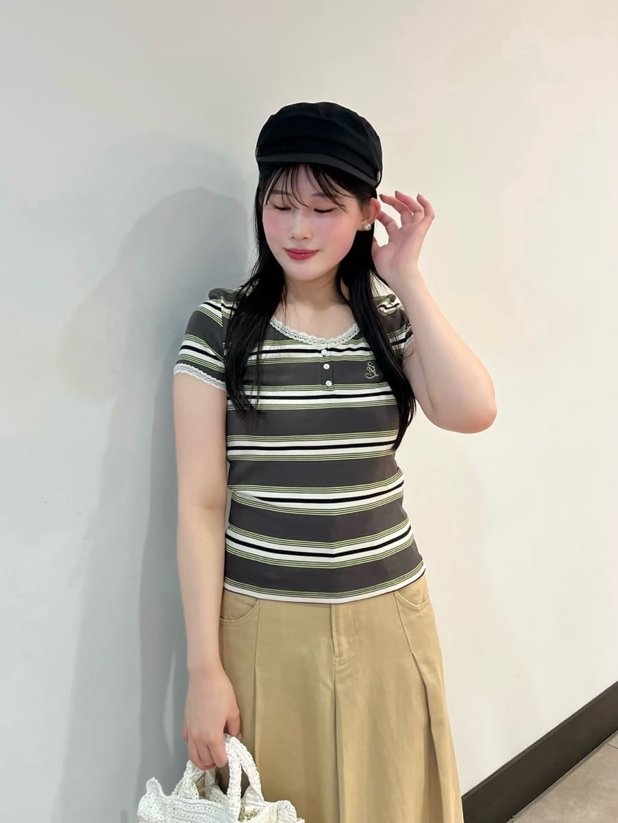 ベージュ系のスカート、グリーン系のTシャツ/カットソー、ホワイト系のショルダーバッグを着用したレディースの春コーディネートの3枚目の写真