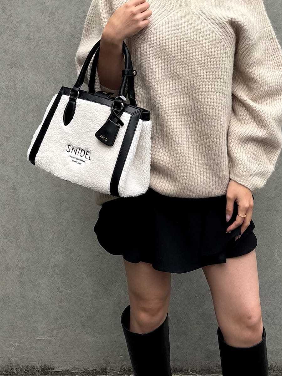 ブラック系のブーツ、ブラック系のハンドバッグ、ブラック系のその他パンツを着用したレディースの秋コーディネートの6枚目の写真