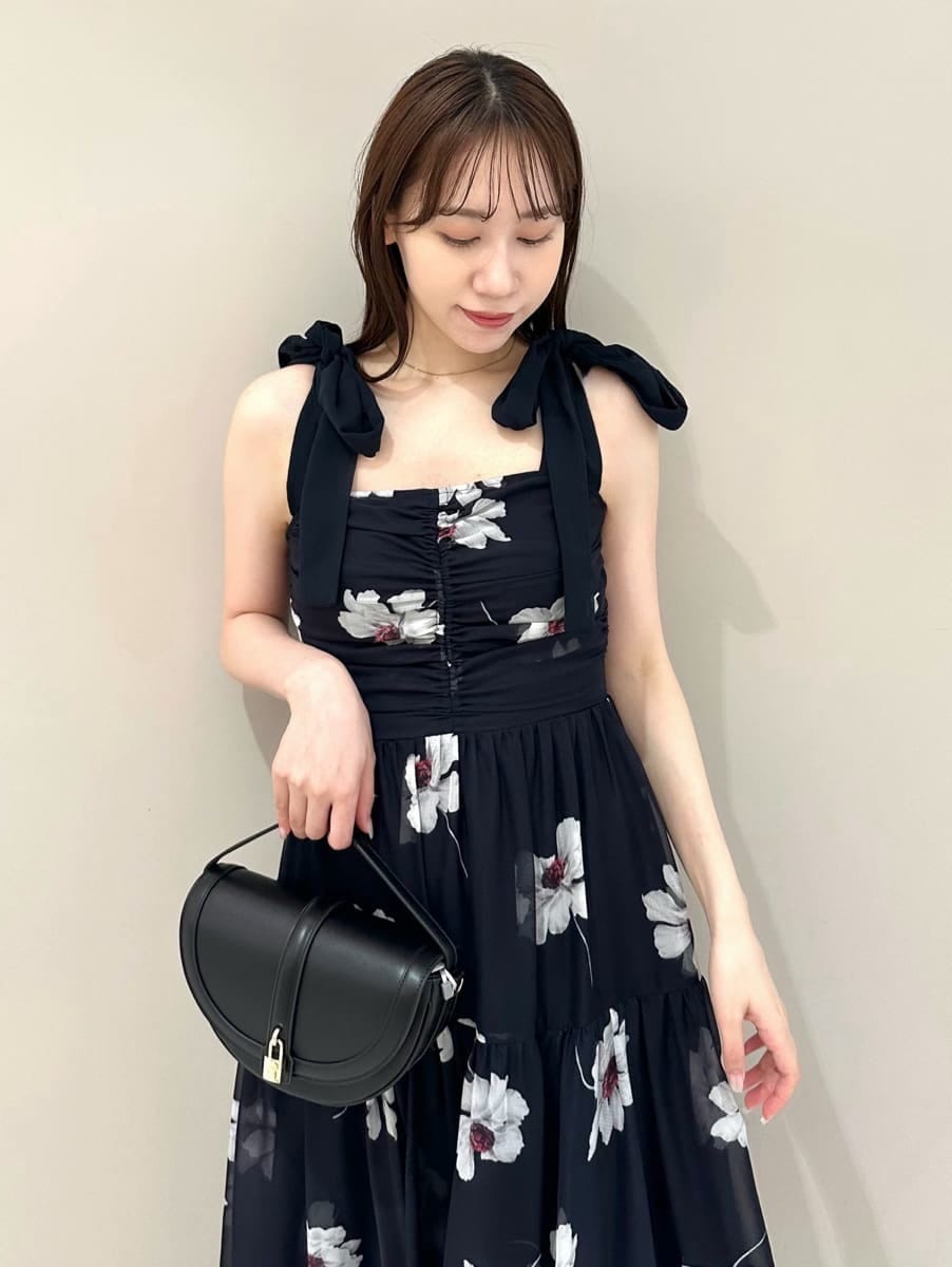 ブルー系のワンピース、ホワイト系のカーディガン/ボレロ、ブラック系のハンドバッグを着用したレディースの夏コーディネートの3枚目の写真