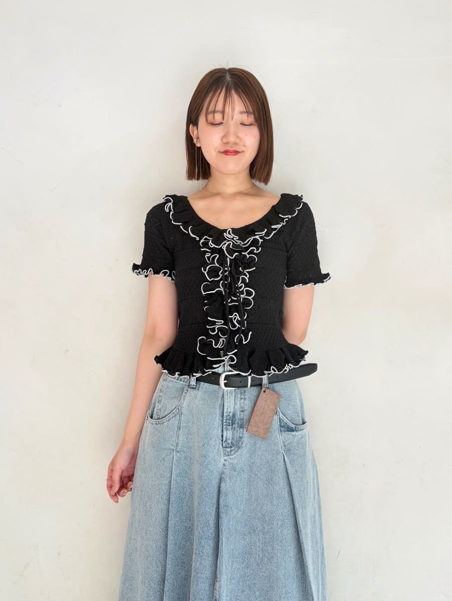 ブルー系のスカート、ホワイト系のサンダル、ブラック系のニット/セーターを着用したレディースの春コーディネートの2枚目の写真